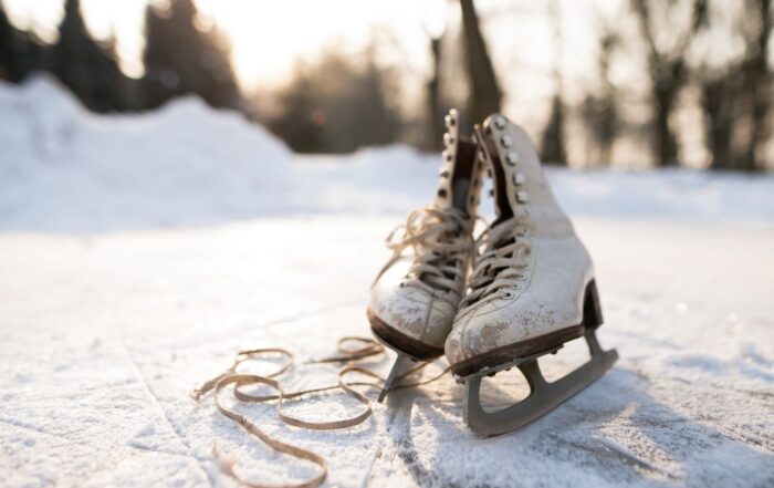 Alte Schlittschuhe auf einem zugefrorenen Teich bei winterlichem Sonnenlicht.
